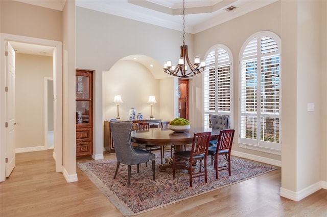 dining room featuring light wood-style floors, visible vents, ornamental molding, and baseboards