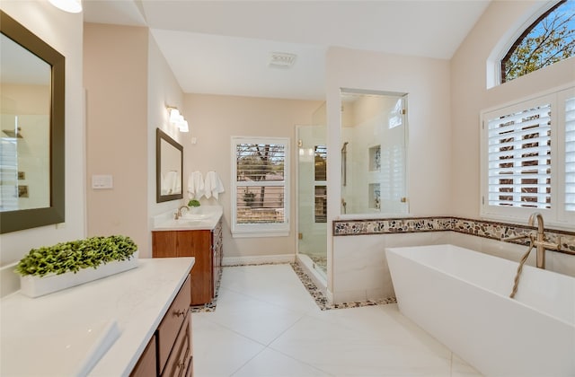 full bathroom featuring tile patterned flooring, two vanities, a sink, a freestanding bath, and a stall shower