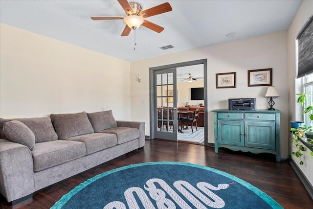 living area featuring a healthy amount of sunlight, a ceiling fan, visible vents, and wood finished floors