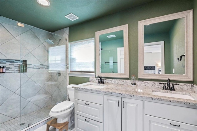 bathroom featuring a sink, a shower stall, and toilet