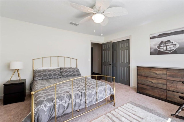 bedroom with a closet, visible vents, ceiling fan, and carpet flooring