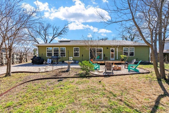 back of property featuring a fire pit, a yard, and a patio area