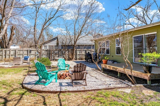 view of yard featuring an outdoor fire pit, fence, and a deck