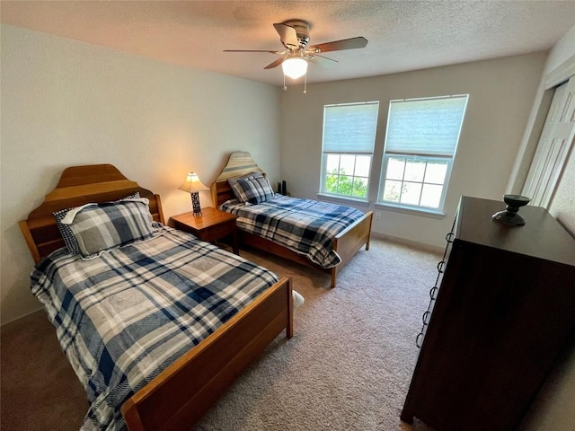 carpeted bedroom featuring a textured ceiling, ceiling fan, and baseboards