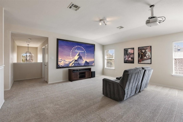 carpeted cinema room featuring lofted ceiling, plenty of natural light, visible vents, and baseboards