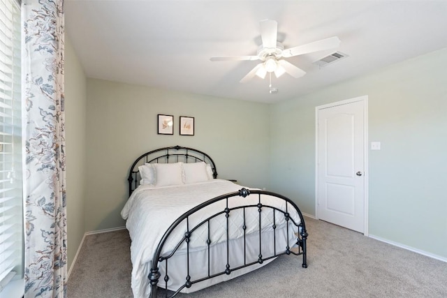 carpeted bedroom featuring baseboards, visible vents, and a ceiling fan