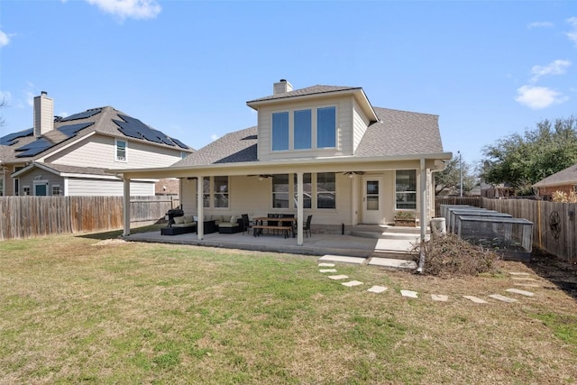 rear view of property featuring a yard, a chimney, a patio, a ceiling fan, and a fenced backyard