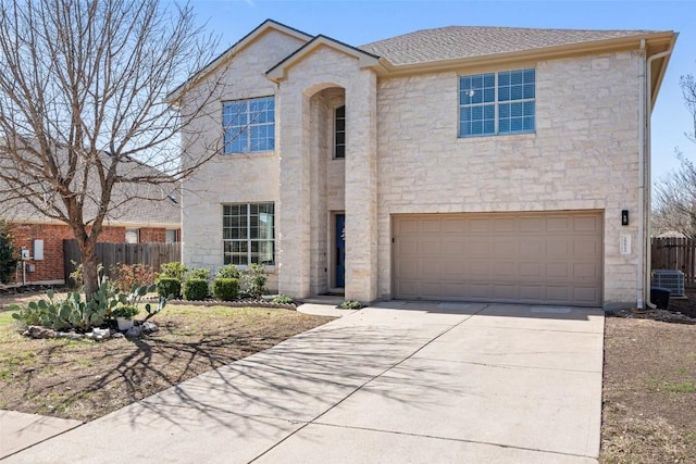 view of front facade featuring concrete driveway, stone siding, roof with shingles, an attached garage, and fence