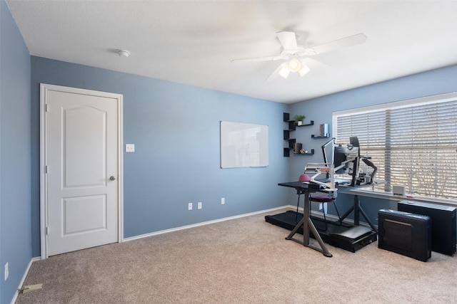 exercise area with ceiling fan, carpet, and baseboards