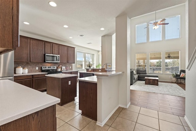 kitchen with light tile patterned floors, visible vents, stainless steel appliances, and light countertops