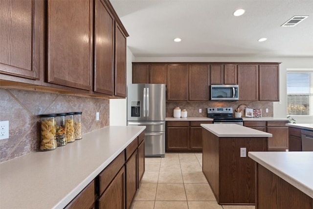 kitchen featuring light tile patterned floors, tasteful backsplash, visible vents, appliances with stainless steel finishes, and light countertops