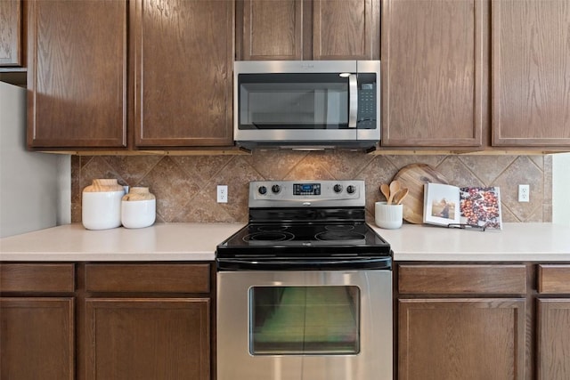 kitchen featuring stainless steel appliances, tasteful backsplash, and light countertops