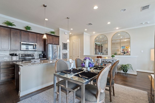 dining room with baseboards, visible vents, dark wood-type flooring, crown molding, and recessed lighting