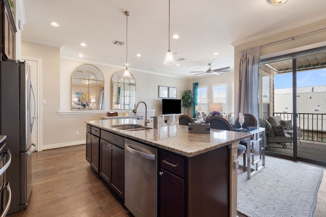 1209 Highknoll Ln, Georgetown, TX 78628 - kitchen with stainless steel appliances, a sink, open floor plan, dark brown cabinets, and light stone countertops