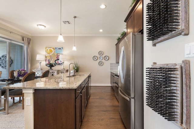 1209 Highknoll Ln, Georgetown, TX 78628 - kitchen with freestanding refrigerator, a sink, a kitchen island with sink, crown molding, and dark brown cabinetry