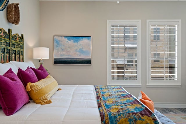 bedroom with baseboards and wood finished floors