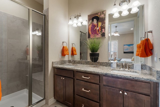 full bathroom featuring double vanity, a stall shower, a sink, and a ceiling fan