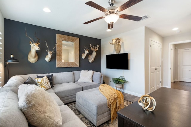 living room with visible vents, baseboards, ceiling fan, and wood finished floors