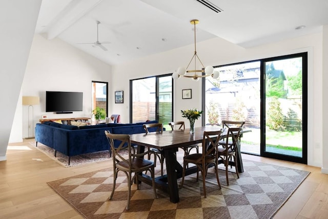 dining space with high vaulted ceiling, beamed ceiling, light wood-type flooring, and a notable chandelier