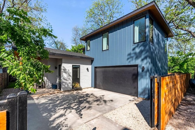 view of front of home with an attached garage, fence, and concrete driveway