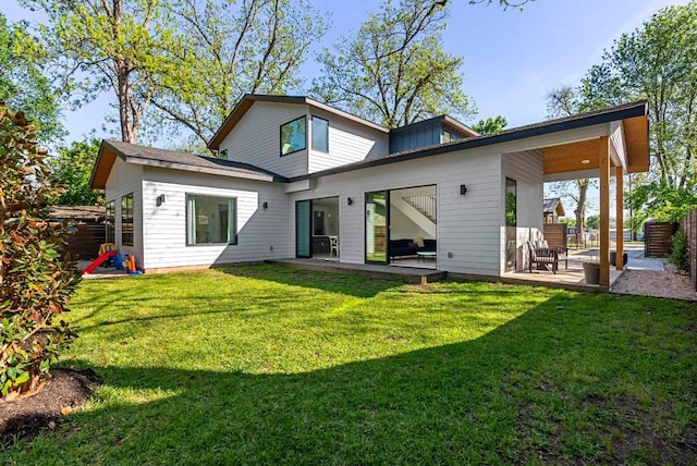 rear view of property featuring a lawn