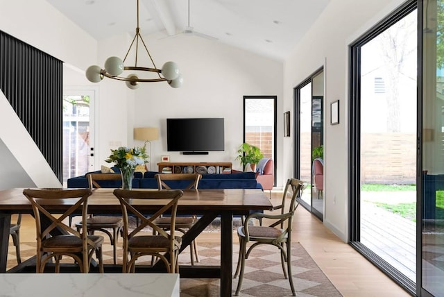 dining area with light wood-style floors, a notable chandelier, and lofted ceiling with beams