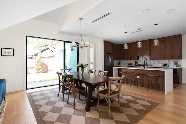 dining space featuring recessed lighting, visible vents, light wood-style flooring, an inviting chandelier, and baseboards