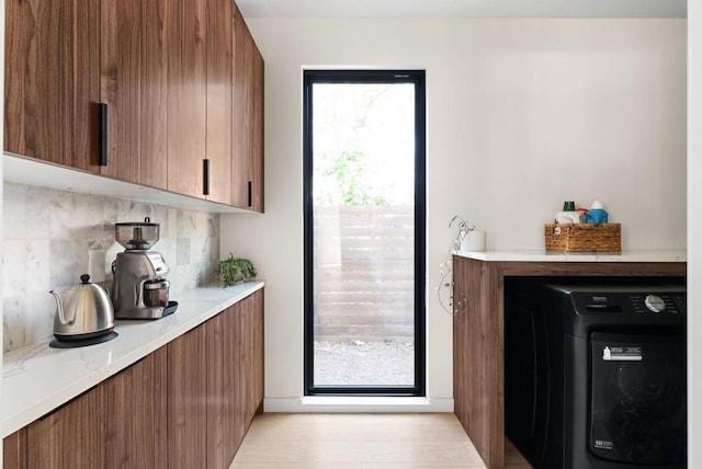 bar featuring washer / dryer and tasteful backsplash