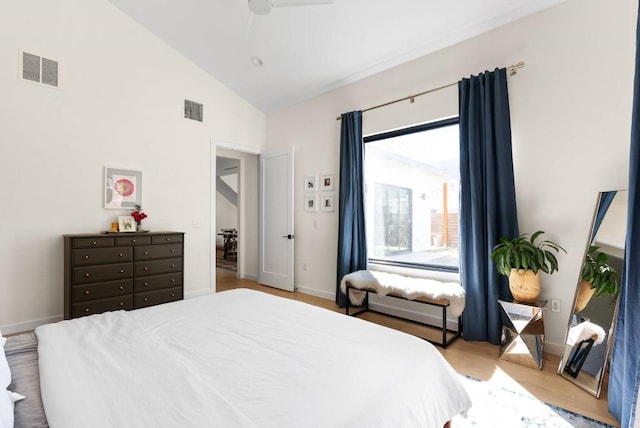 bedroom with baseboards, visible vents, vaulted ceiling, and wood finished floors