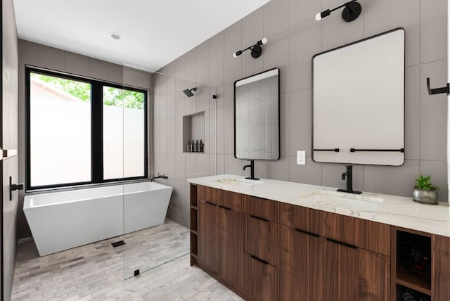 bathroom featuring a sink, tile walls, and double vanity