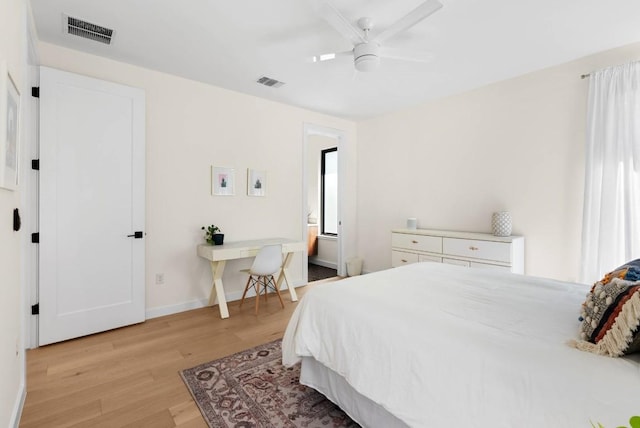 bedroom featuring a ceiling fan, light wood-style flooring, visible vents, and baseboards