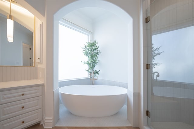 full bathroom with a freestanding tub, a shower stall, and vanity