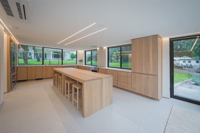 2301 Manana St, Austin, TX 78730 - kitchen featuring modern cabinets, butcher block counters, a breakfast bar, and light brown cabinetry