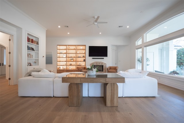2301 Manana St, Austin, TX 78730 - living room with a fireplace, a ceiling fan, light wood-type flooring, built in features, and crown molding