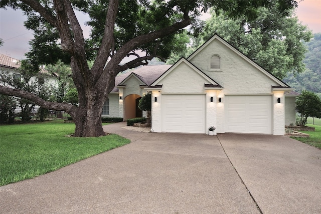 single story home with a garage, concrete driveway, and a lawn