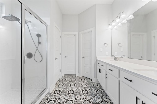 bathroom with double vanity, a stall shower, and a sink