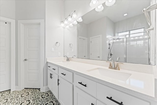 bathroom featuring a closet, a sink, a shower stall, and double vanity