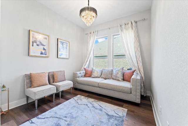 living area with a notable chandelier, baseboards, and wood finished floors