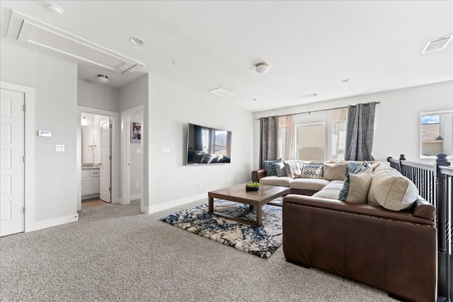 living room featuring visible vents, a wealth of natural light, carpet, and attic access