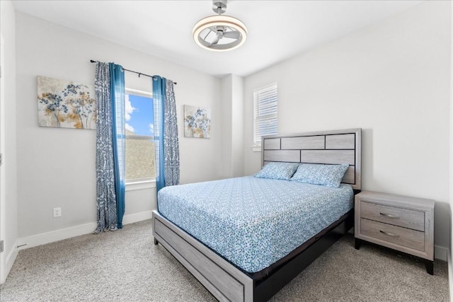 bedroom featuring multiple windows, carpet, and baseboards