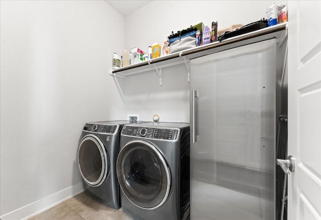 laundry room featuring light tile patterned floors, laundry area, independent washer and dryer, and baseboards