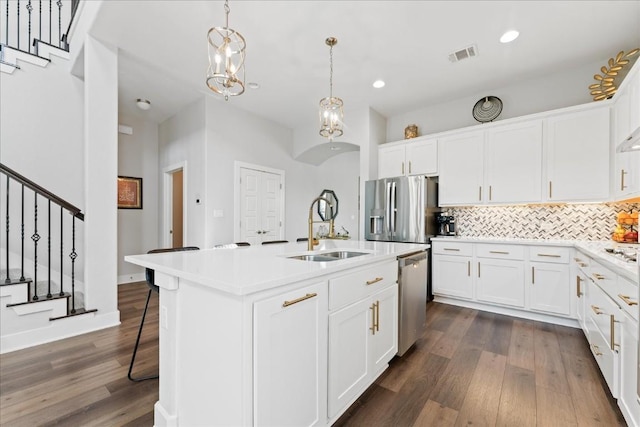 kitchen with tasteful backsplash, visible vents, appliances with stainless steel finishes, dark wood-type flooring, and a sink