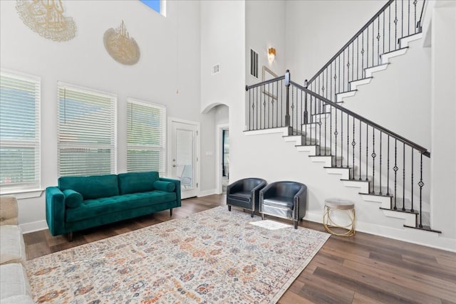 living area with baseboards, wood finished floors, and a healthy amount of sunlight