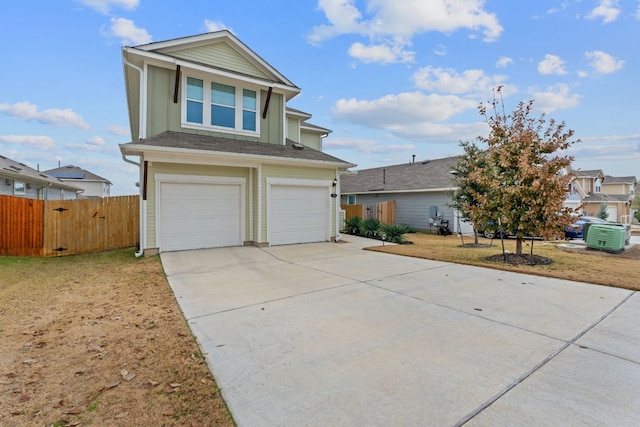 traditional home featuring a garage, driveway, fence, and a front yard