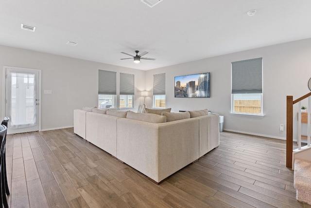 living room featuring stairs, plenty of natural light, and wood finished floors