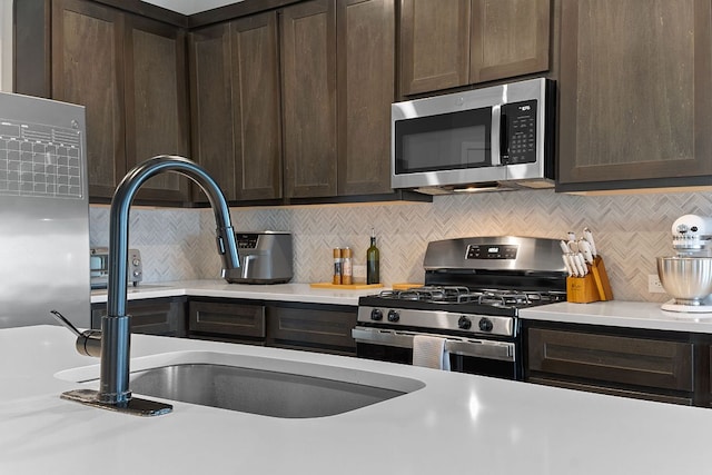 236 Stein Rd, Georgetown, TX 78626 - kitchen with appliances with stainless steel finishes, dark brown cabinets, light countertops, and backsplash