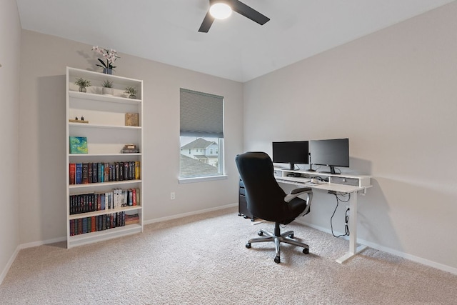 carpeted office with ceiling fan and baseboards