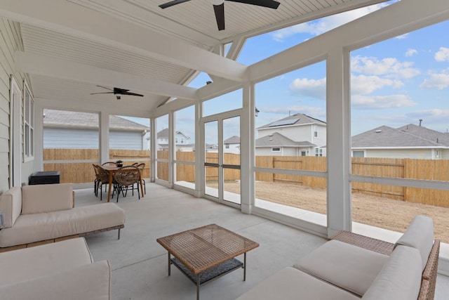 sunroom / solarium featuring vaulted ceiling, a residential view, and a ceiling fan