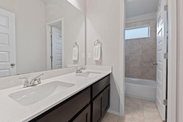 bathroom featuring baseboards, double vanity, a sink, and tile patterned floors