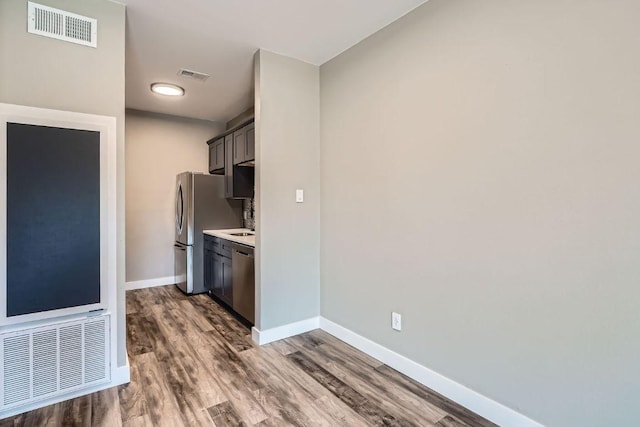 kitchen with stainless steel appliances, wood finished floors, and visible vents